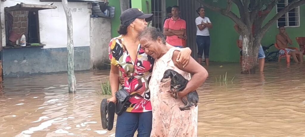 Adulta mayor con su mascota en brazos que se salvó de ser llevada por la creciente. El Pilón